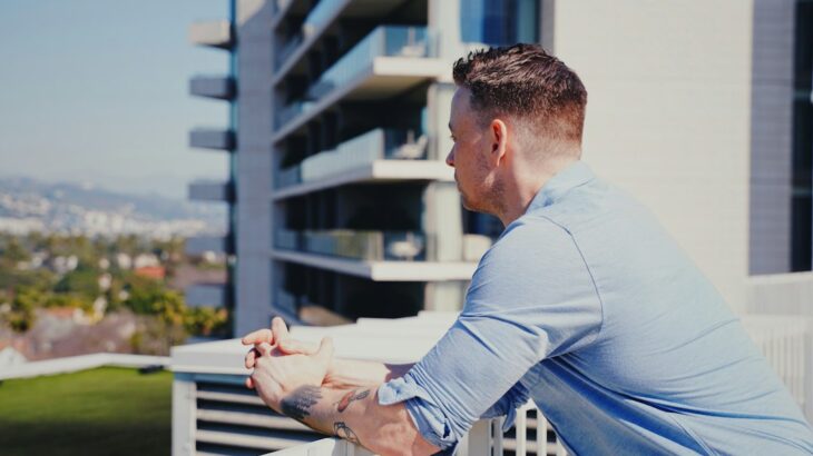 Professional real estate entrepreneur carefully analyzes two different modern house models on a table, representing a comp...